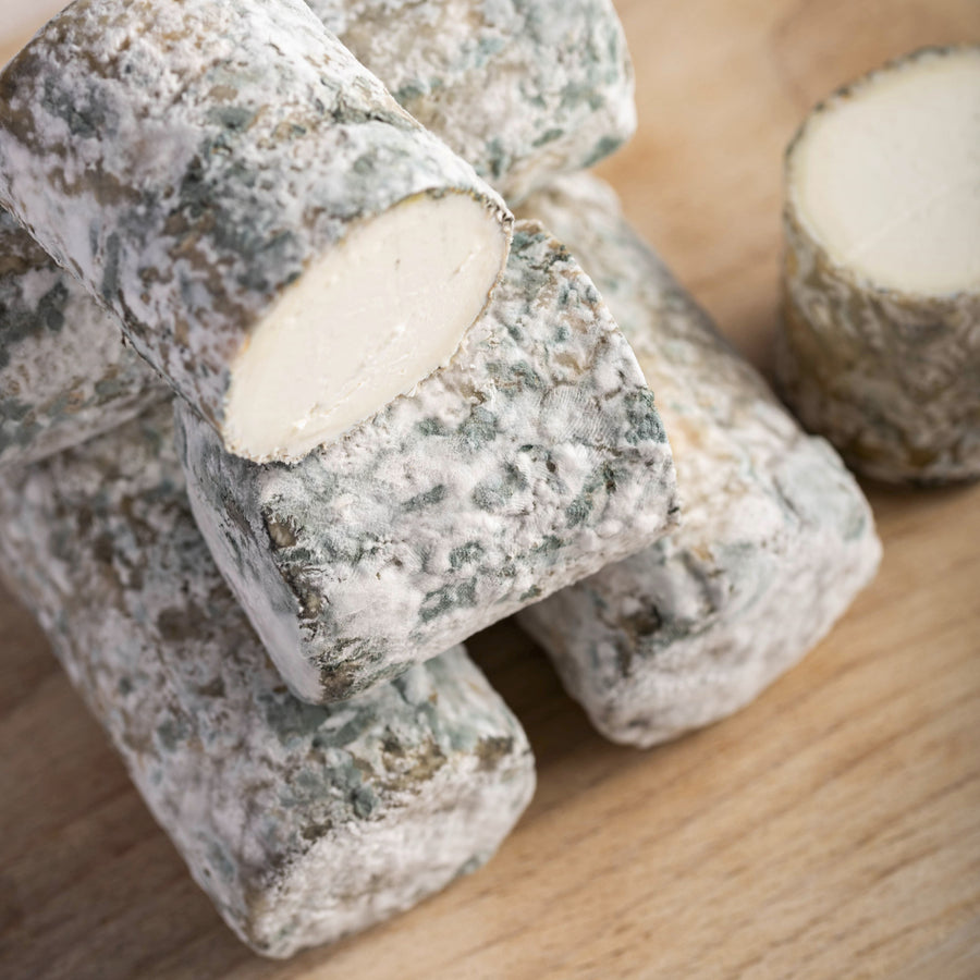 Close up of Oiselliere French goat's cheese on a wooden board.